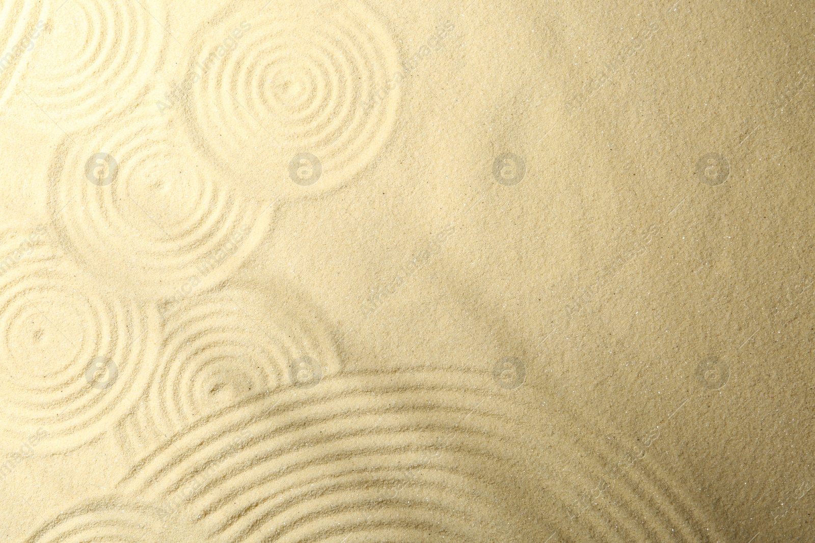 Photo of Zen rock garden. Circle patterns on beige sand, top view