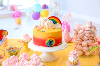 Photo of Table with birthday cake and delicious treats indoors