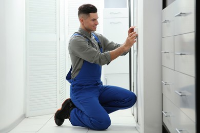 Photo of Professional electrician repairing light switch in room