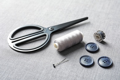 Photo of Set of tailoring accessories on grey fabric