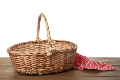 Empty wicker basket and cloth on wooden table against white background. Easter holiday