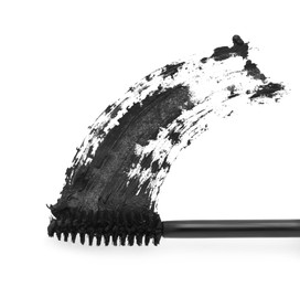 Applicator and black mascara smear on white background, top view