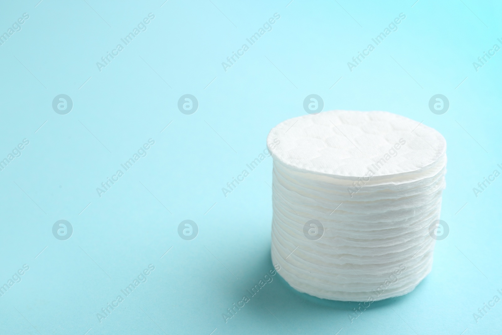 Photo of Stack of cotton pads on color background. Space for text