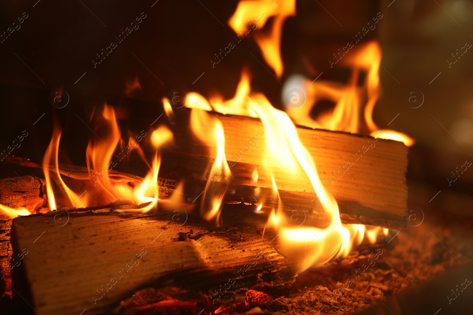 Photo of Fireplace with burning wood, closeup view. Winter vacation