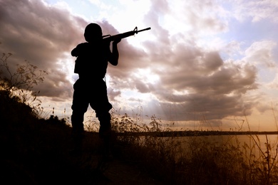 Photo of Soldier with machine gun patrolling outdoors. Military service