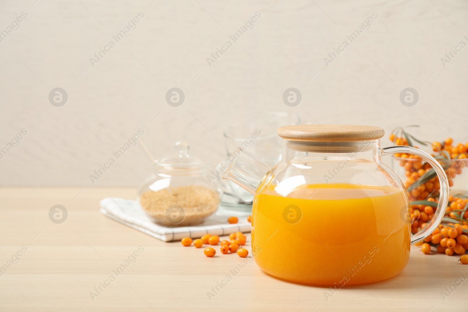 Photo of Delicious sea buckthorn tea on wooden table. Space for text