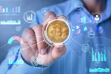 Image of Man holding golden bitcoin on color background, closeup