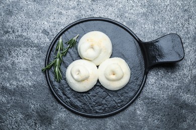 Photo of Delicious burrata cheese with rosemary on grey table, top view