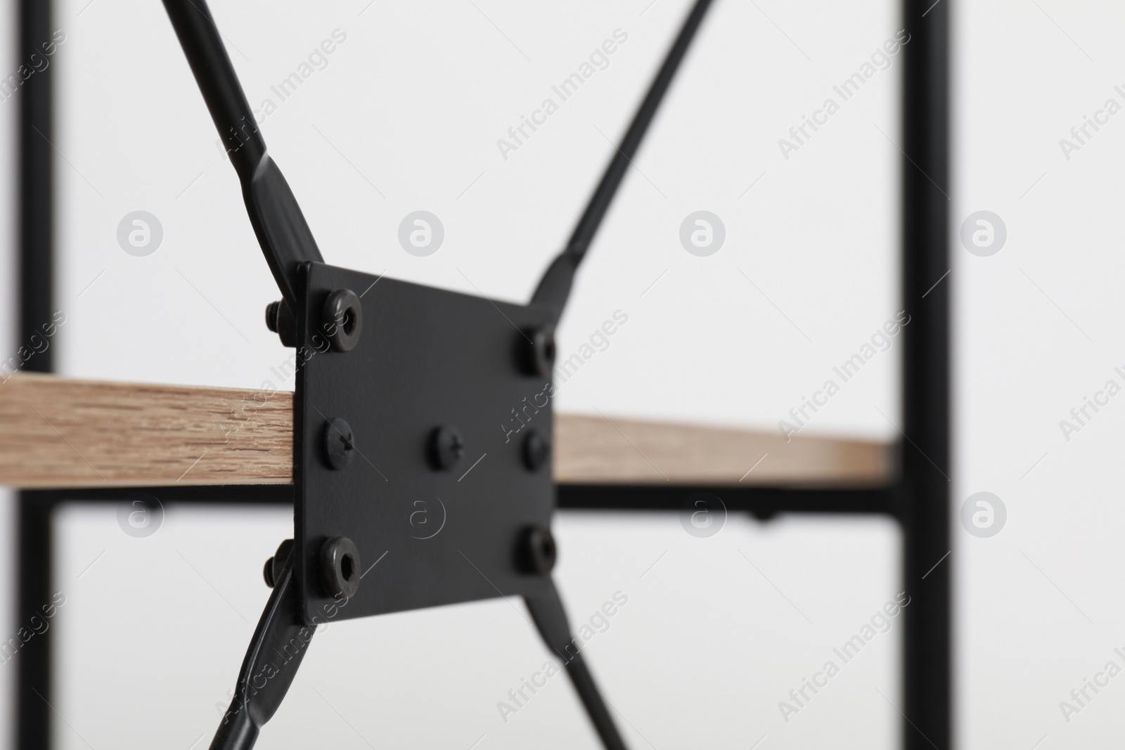 Photo of Rack with black metal connecting detail on light background, closeup