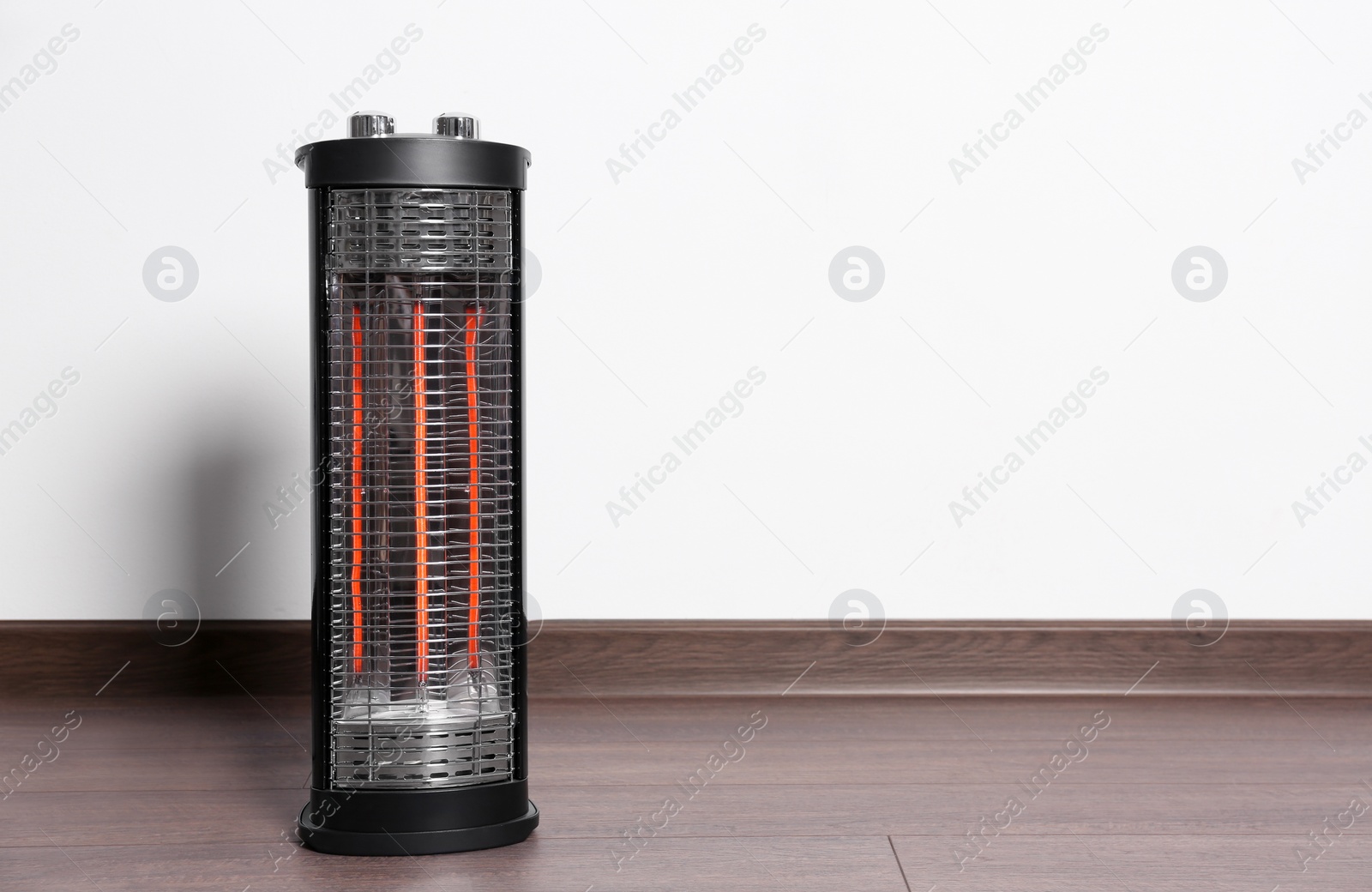 Photo of New modern electric heater on floor in room, space for text