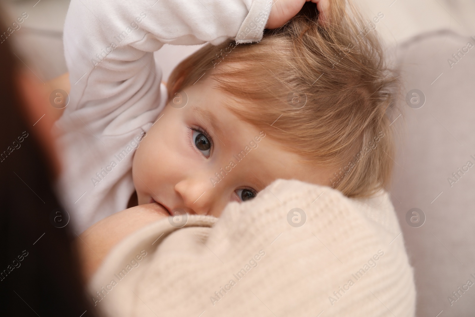 Photo of Woman breastfeeding her little baby, closeup view