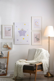 Stylish child's room interior with comfortable armchair and beautiful pictures