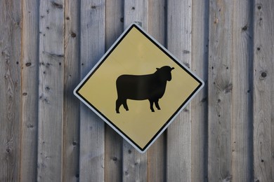 Photo of Sign with picture of sheep on wooden wall. Farm animal