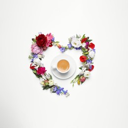 Photo of Beautiful heart made of different flowers and coffee  on white background, top view