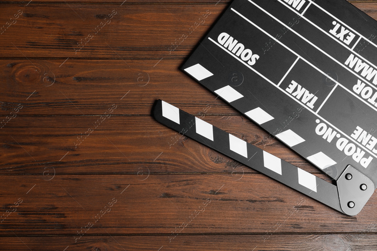 Photo of Clapperboard on wooden table, top view with space for text. Cinema production