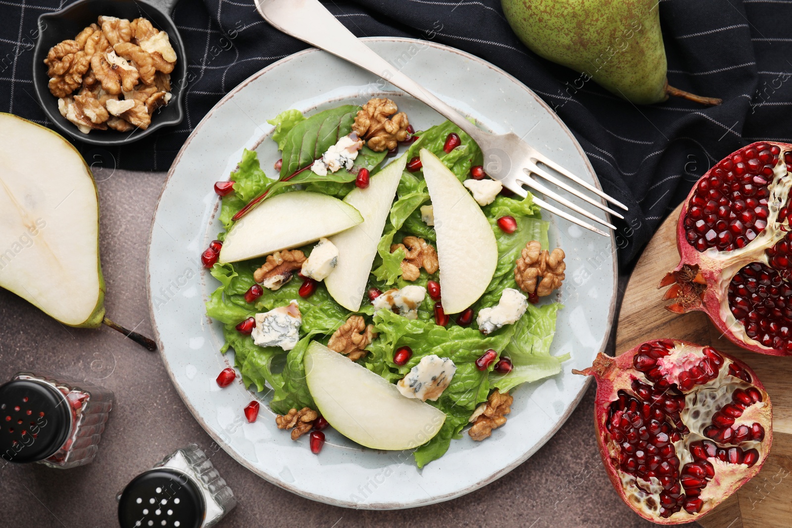 Photo of Delicious pear salad served on dark textured table, flat lay