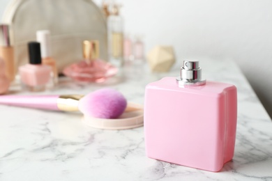 Photo of Bottle of perfume and cosmetics on marble table. Space for text