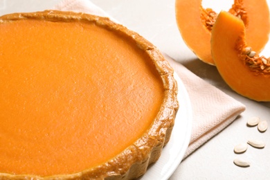 Photo of Fresh delicious homemade pumpkin pie on light table, closeup