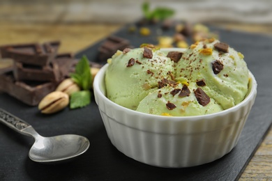 Delicious green ice cream served in ceramic bowl on table