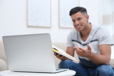 Teacher giving online lesson during quarantine, focus on laptop. Studying at home