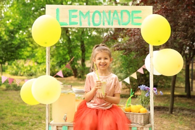 Photo of Little girl with natural lemonade in park