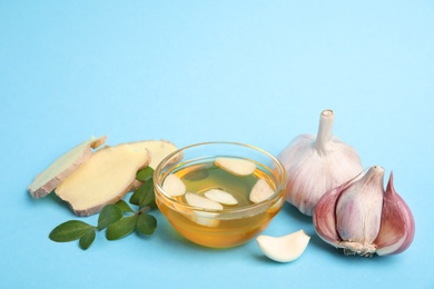 Photo of Composition with garlic and other cold remedies on blue background