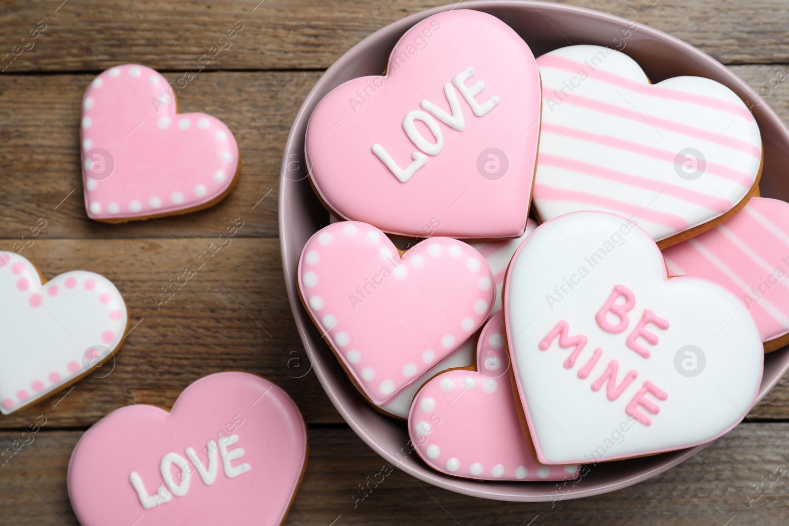 Photo of Decorated heart shaped cookies on wooden table, flat lay. Valentine's day treat