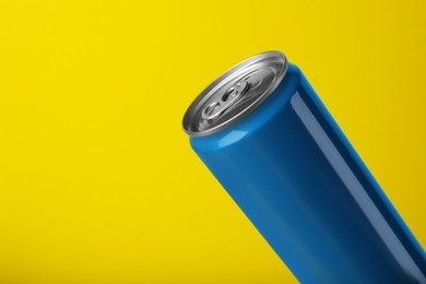 Photo of Blue can of energy drink on yellow background, closeup. Space for text