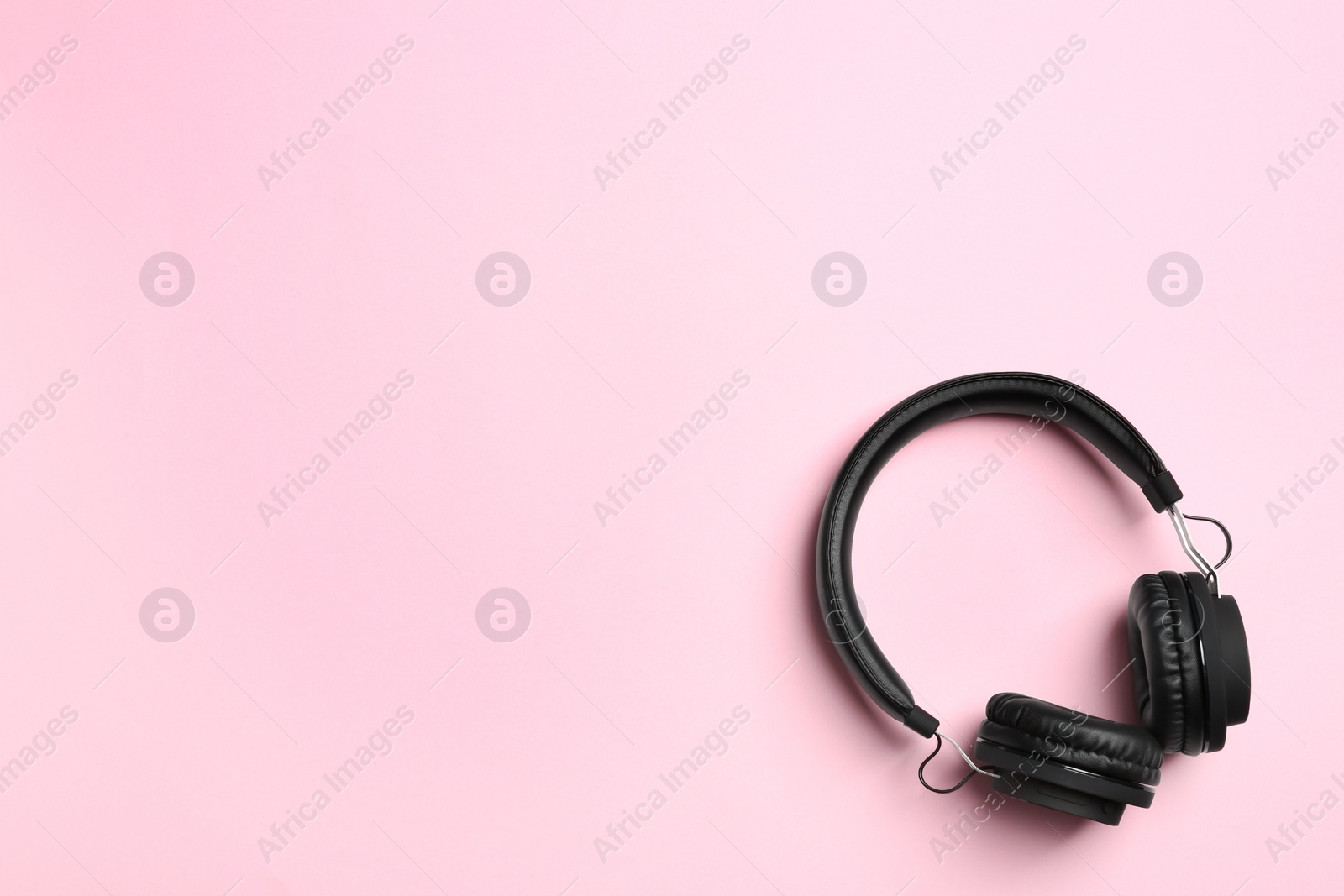 Photo of Stylish headphones on color background, top view. Space for text