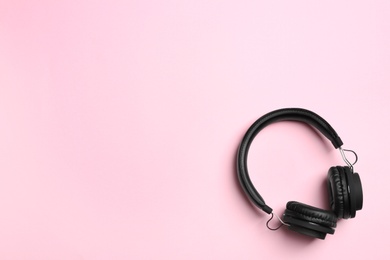 Stylish headphones on color background, top view. Space for text