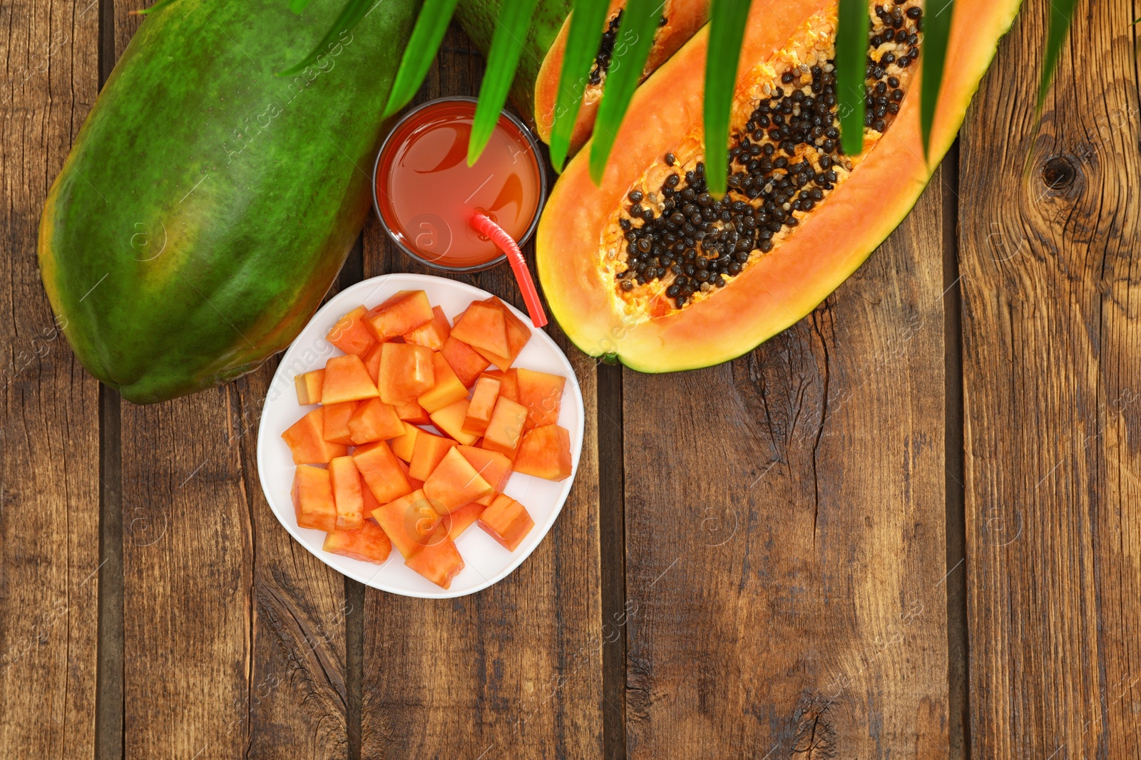 Photo of Flat lay composition with fresh juicy papayas on wooden table, space for text