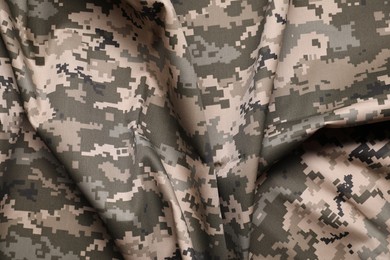 Texture of crumpled camouflage fabric as background, top view