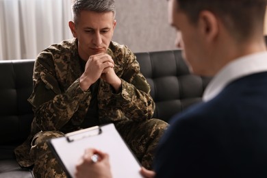 Photo of Professional psychotherapist working with military man in office