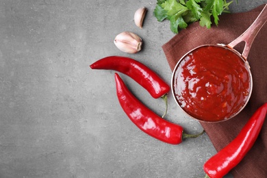 Photo of Pan of hot chili sauce with ingredients on table, flat lay. Space for text