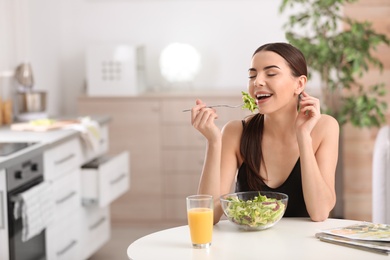 Photo of Young woman in fitness clothes having healthy breakfast at home. Space for text