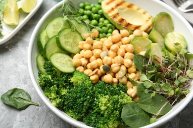 Photo of Healthy meal. Tasty vegetables and chickpeas in bowl on grey table, closeup