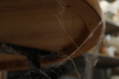 Photo of Old cobweb on table in room, closeup