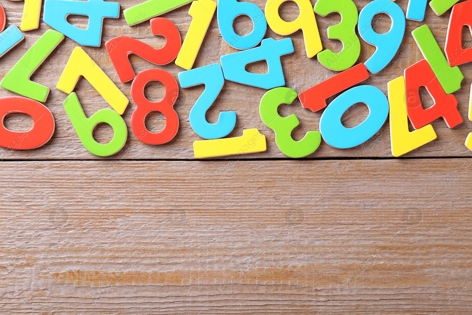 Photo of Colorful numbers on wooden table, flat lay. Space for text