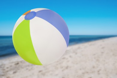 Colorful inflatable beach ball and seascape on background
