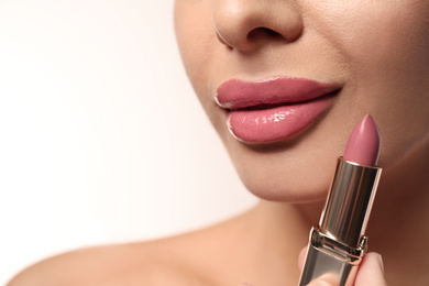 Woman with pink lipstick on light background, closeup