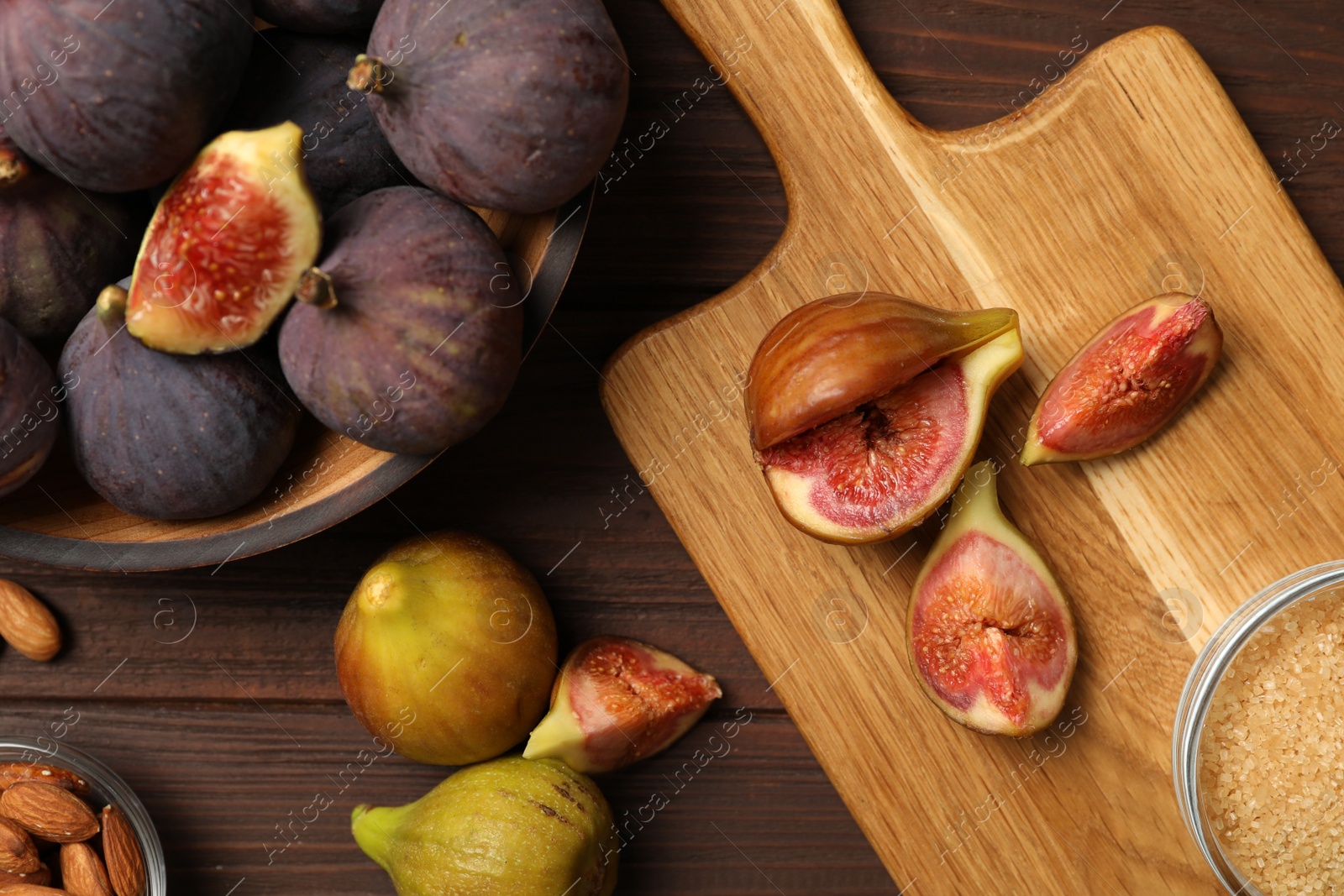 Photo of Tasty raw figs on wooden table, flat lay