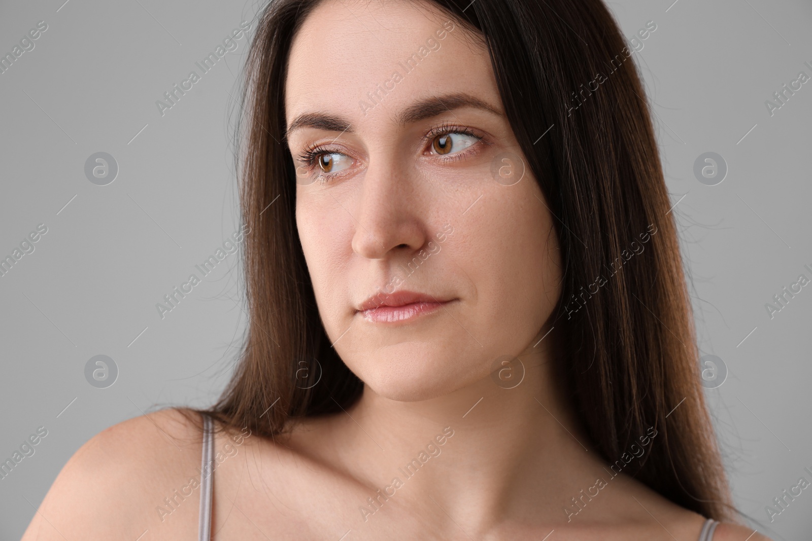 Photo of Portrait of beautiful young woman on light grey background, closeup