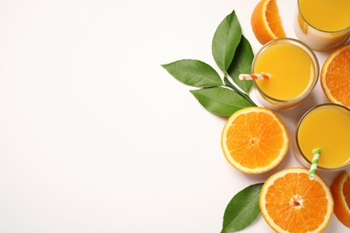 Photo of Glasses of orange juice and fresh fruits on white background, top view