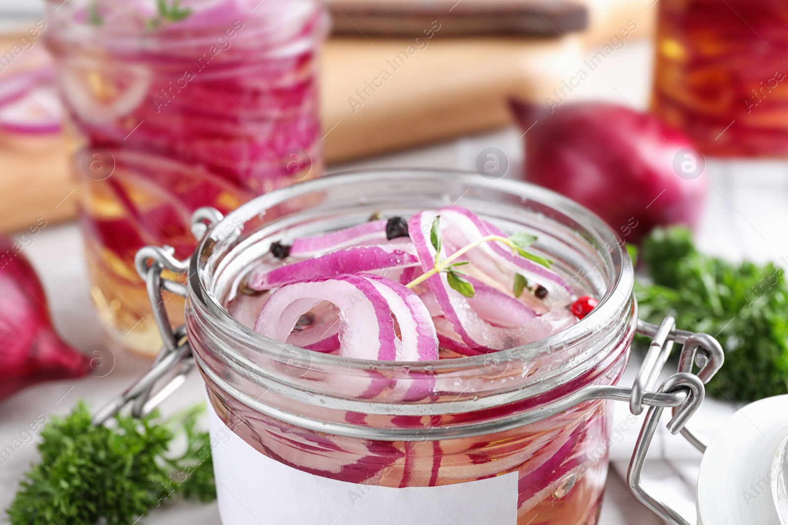 Photo of Jar of pickled onions on table, closeup