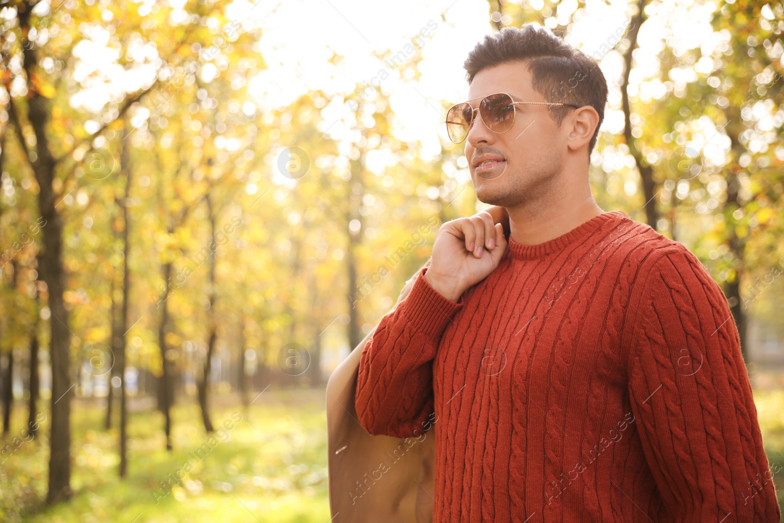 Photo of Handsome man walking in park on autumn day