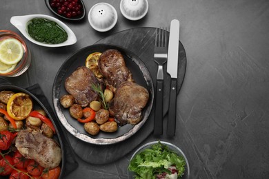 Photo of Tasty beef tongue pieces with potatoes and ingredients on grey table, flat lay. Space for text