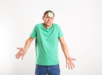 Emotional man with question mark on white background