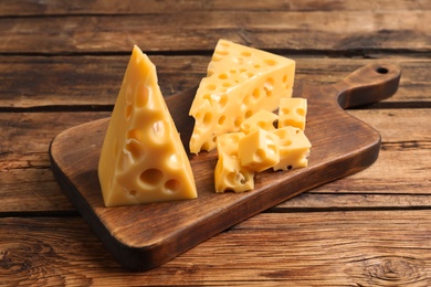 Tasty fresh cheese and board on wooden table,