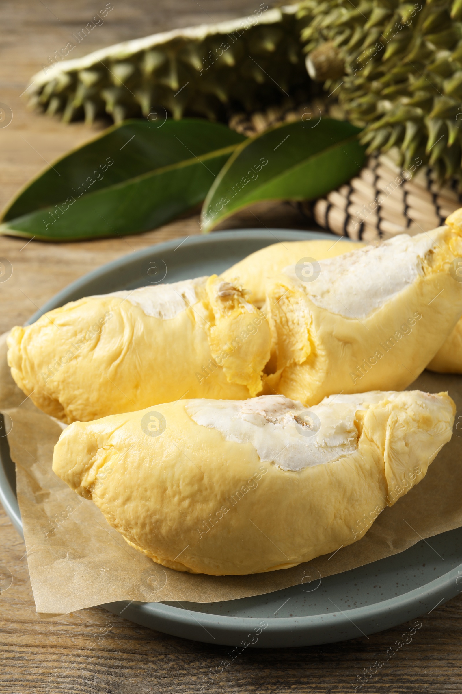 Photo of Plate with fresh ripe durian on wooden table, closeup