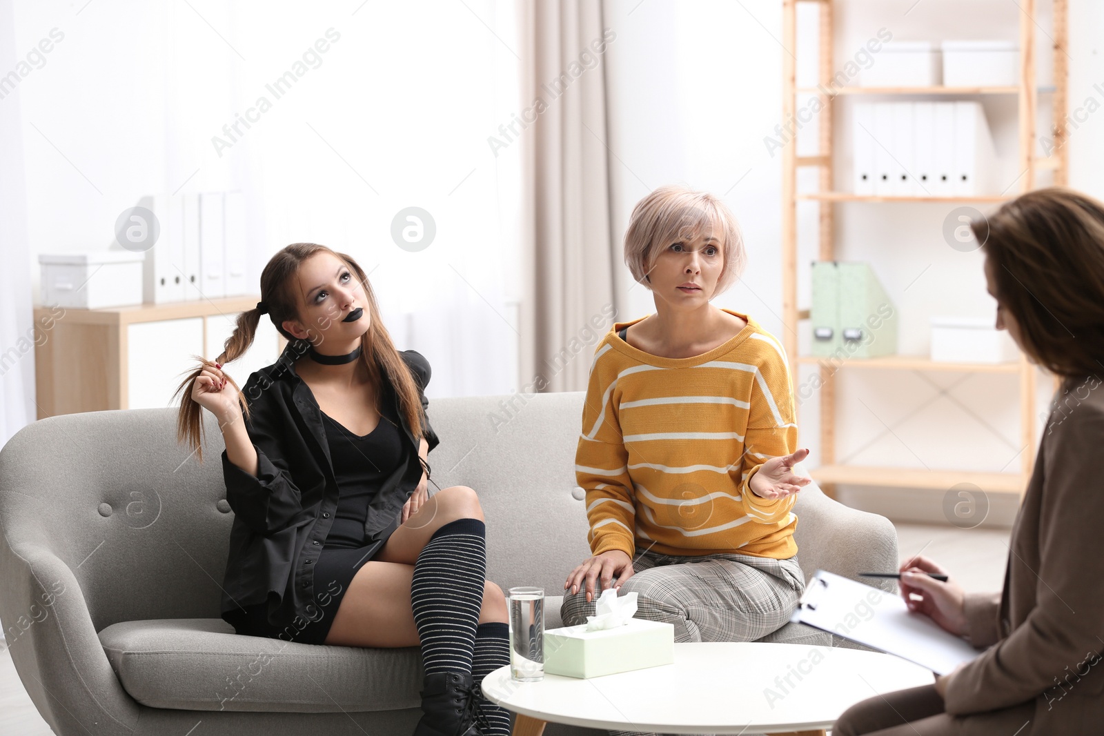 Photo of Psychotherapist working with teenage goth girl and her mother in office